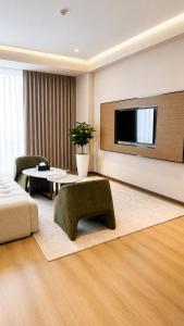 a living room with a couch and a tv on a wall at NOMAD Luxe Hotel in Zharkent