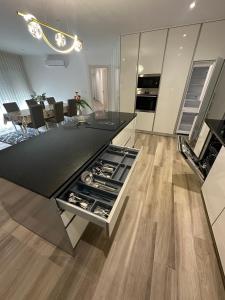 a kitchen with a black counter and wooden floors at Apartamento As T3 Pombal in Pombal