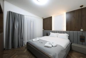 a bedroom with a large bed with two towels on it at Montéa Villa in Brezovica