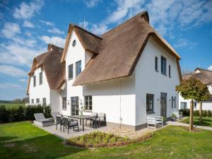 a large white house with a thatched roof at Reetidyll am Haff in Stolpe auf Usedom