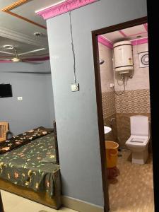 a small room with a bed and a toilet at Friends corner Dharamshala in Dharmsāla
