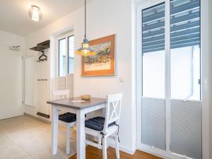 a dining room with a white table and chairs at Quartier 7, App 06 in Ahlbeck +5 photos