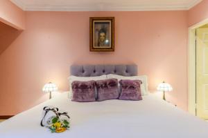 a bedroom with a large white bed with purple pillows at Villa Simonne in Johannesburg