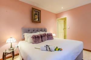 a bedroom with a large white bed with purple walls at Villa Simonne in Johannesburg +159 photos