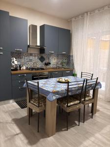 a kitchen with a table and some chairs and a kitchen withuclear at Vacanze a 2 passi dal mare in Giardini Naxos