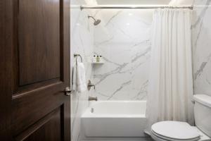 a bathroom with a toilet and a tub and a sink at Delux Inn Mesquite Near I-30 Dallas in Mesquite +11 photos