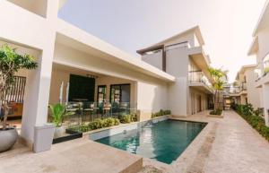 a villa with a swimming pool and a house at Luxury Penthouse, Pool, Bbq, Private Terrace in Pueblo Bavaro