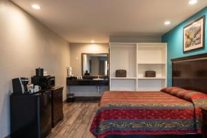 a hotel room with a bed and a sink at Delux Inn Mesquite Near I-30 Dallas in Mesquite
