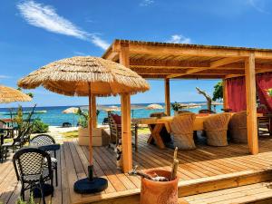 a wooden deck with a table and an umbrella at Maison "LA ROSALINDA-2B" Ghisonaccia in Ghisonaccia