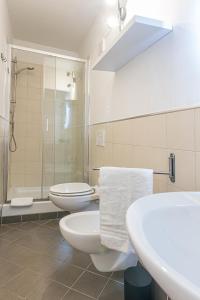 a white bathroom with two toilets and a shower at Titina Apartment Novoli Close to Center & Airport in Florence