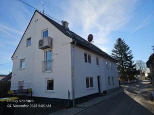 a white house on the side of a street at Schneiders Apartment Style House in Trunkelsberg