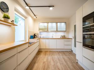 a kitchen with white cabinets and a large window at Ferienhaus Amica in Heringsdorf