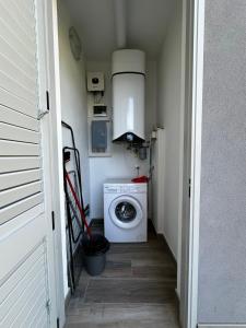 a small laundry room with a washing machine in it at Polinesia 5 in Lido delle Nazioni