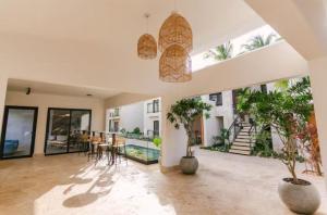 a living room with potted plants and a dining room at Luxury Penthouse, Pool, Bbq, Private Terrace in Pueblo Bavaro