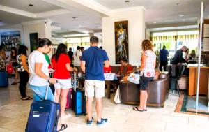 Eine Gruppe von Menschen mit Gepäck steht in einer Lobby. in der Unterkunft Marmaris Alkan Hotel in Marmaris
