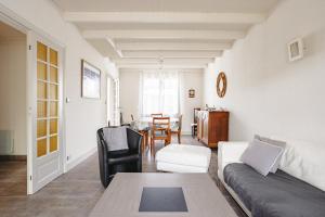 a living room with a couch and a table at Cottage Chaleureux Proche Ocean in Salles-sur-Mer