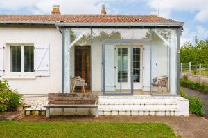 a white house with a bench in front of it at Cottage Chaleureux Proche Ocean in Salles-sur-Mer