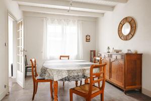 a dining room with a table and chairs and a mirror at Cottage Chaleureux Proche Ocean in Salles-sur-Mer