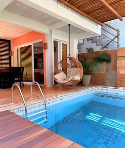 a pool with a swing and a house at Refugio de Luxo com Piscina e Jacuzzi em Pipa in Pipa