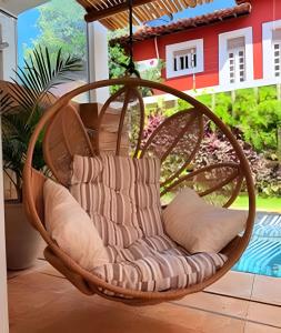 a wicker swing chair hanging from a porch at Refugio de Luxo com Piscina e Jacuzzi em Pipa in Pipa +95 photos