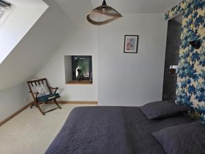 a bedroom with a bed and a chair and a mirror at Gîte Le Cheix d'Arches in Arches