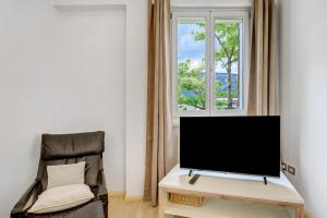 a flat screen tv sitting on a desk next to a window at Apartment Gerwies in Bronzolo