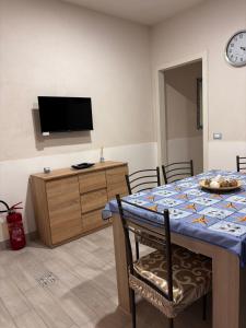 a dining room with a table and a tv at Vacanze a 2 passi dal mare in Giardini Naxos