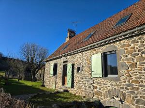 a stone house with a green door and windows at Gîte Le Cheix d'Arches in Arches