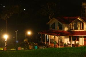 a house at night with lights in front of it at The Attic at Infinity Valley in Kotagiri