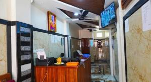 an office with a reception desk and a tv on the wall at A One Residency in Nāgercoil