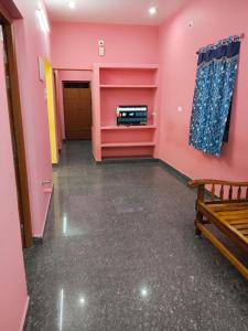an empty room with pink walls and a bench at D S Villa with swimming pool in Kuilapayam
