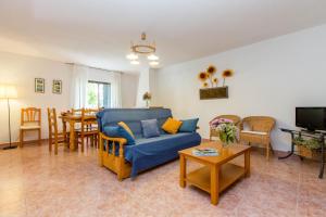 a living room with a blue couch and a table at Villa-Piedralaves-aMatalasviñas-piscina-4 viviendas in Piedralaves