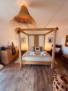 a bedroom with a canopy bed with a tv on it at Maison "LA ROSALINDA-2B" Ghisonaccia in Ghisonaccia