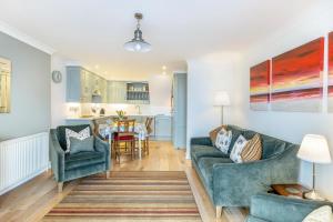 a living room with two blue couches and a kitchen at 2 Bed in Woolacombe oc-shore1 in Woolacombe