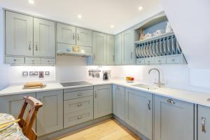 a kitchen with white cabinets and a sink at 2 Bed in Woolacombe oc-shore1 in Woolacombe +20 photos