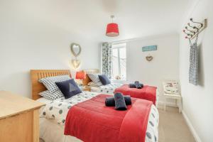 a bedroom with two beds and a red blanket at 2 Bed in Woolacombe oc-shore1 in Woolacombe