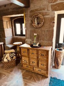 a wooden dresser in a room with a stone wall at Vila Adelaide in Campos +111 photos