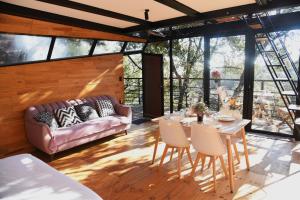a living room with a couch and a table and chairs at Cabaña Gokotta, Punta del Bosque in Huasca de Ocampo
