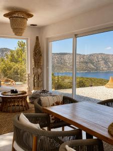 a living room with a table and chairs and a large window at Villa Issima Samos, Breathtaking Sea View & Jacuzzi in Samos