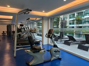 a gym with tread machines and a swimming pool at Aleksandra Royal Lee in Ban Bo Han