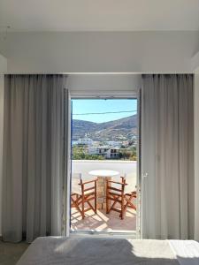 a bedroom with a balcony with a table and chairs at Hotel Faros in Ios Chora