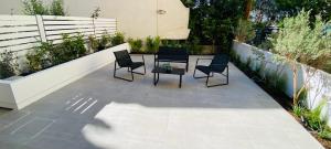 a patio with four chairs and a table on it at Magio House in Ixia
