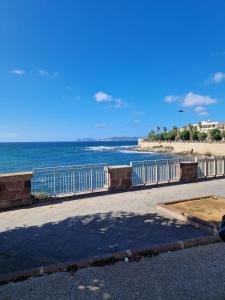 a sidewalk next to a beach with the ocean at Casa vacanze vento di mare in Alghero