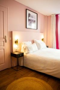 a bedroom with a large white bed and a table at Hôtel Le G (ex Le Genève) in Nice