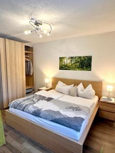 a bedroom with a large bed with two lamps at LechBrugger Berg Appartements in Holzgau