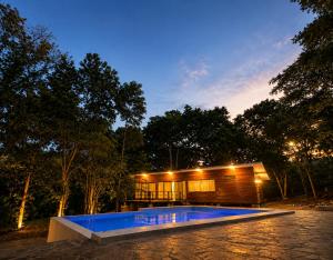 a house with a swimming pool in front of it at Shapaja Glamping in Tarapoto