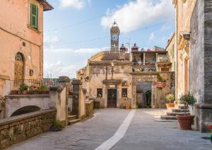 an old building with a clock tower in the distance at La casetta del masso in Sorano