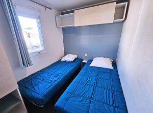 two beds in a small room with blue walls at VVF Labenne - Océan in Labenne +20 photos