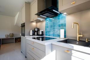 a kitchen with white cabinets and a sink at Ferienhaus Reet & Meer N 2 in Bansin +21 photos