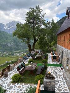a patio with tables and chairs and a building at Guesthouse Bec Villi in Theth